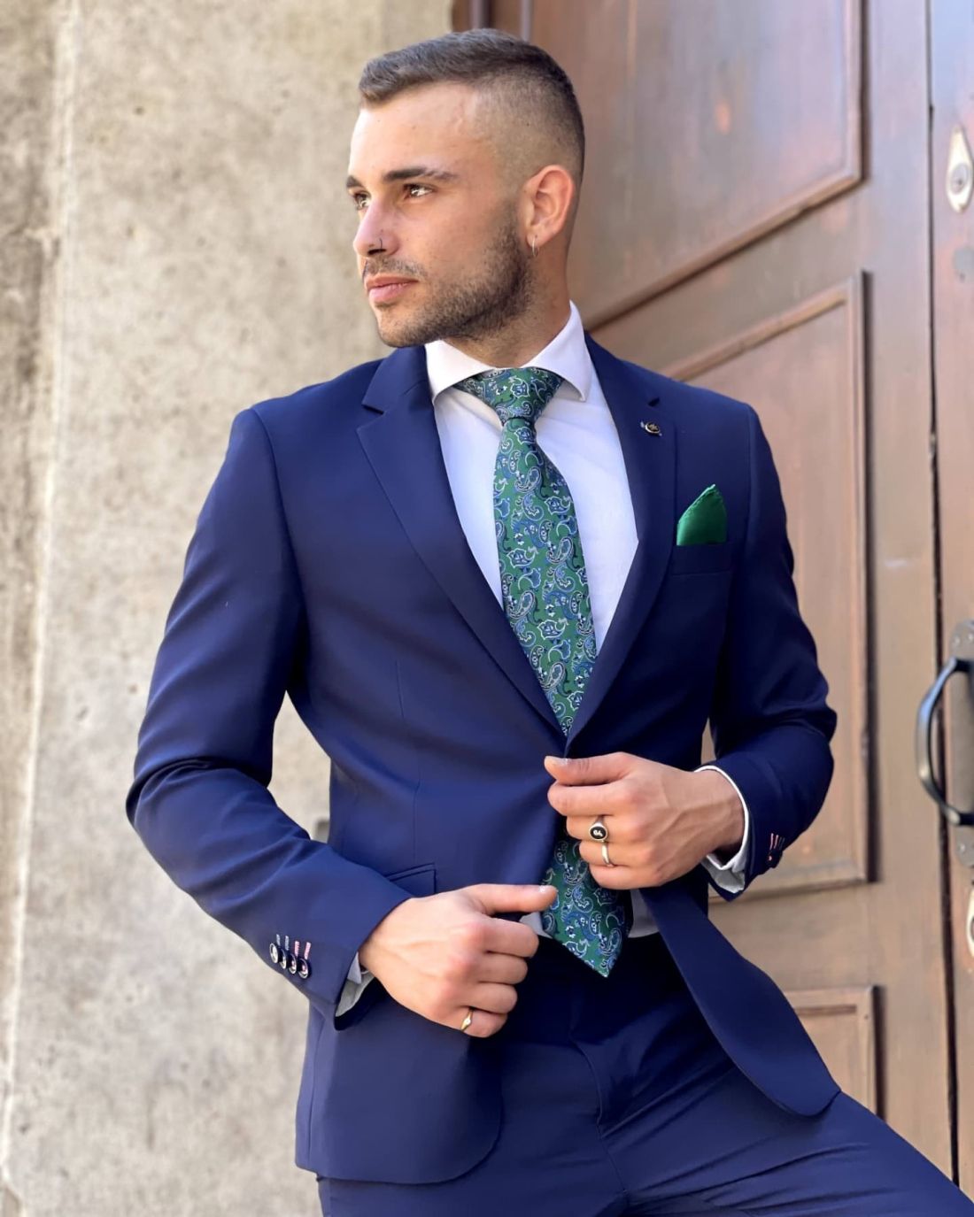 Traje azul marino con corbata verde en tendencia
