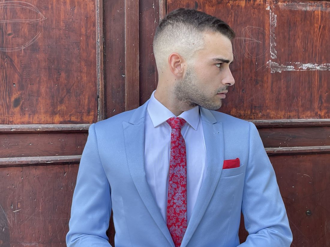 Traje azul claro con corbata roja